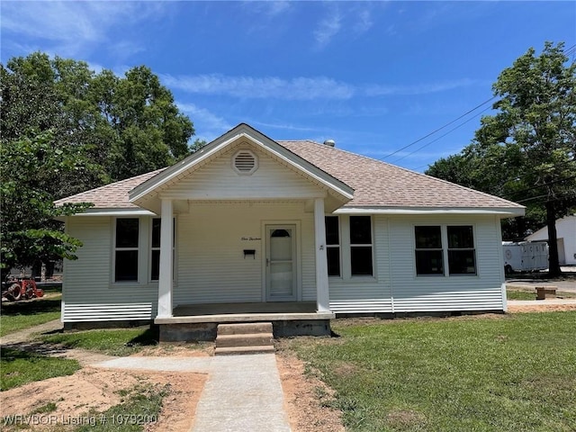 bungalow featuring a shingled roof, crawl space, and a front yard