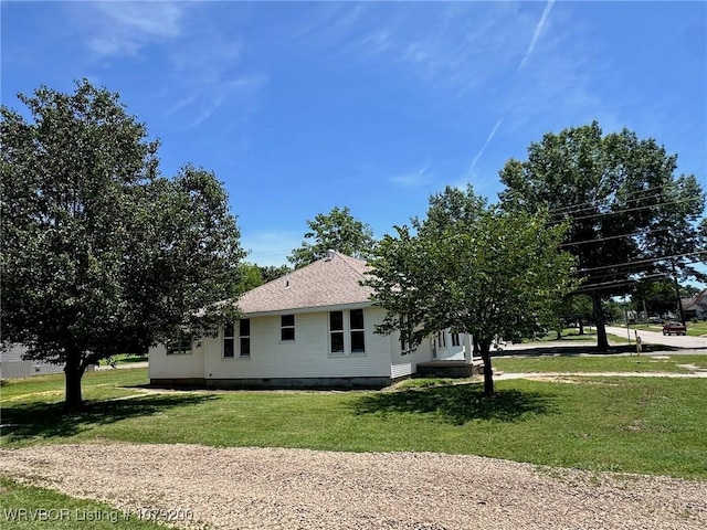 view of property exterior featuring a yard, crawl space, and roof with shingles