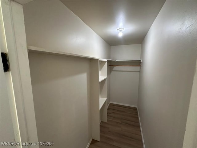 spacious closet with dark wood-style flooring