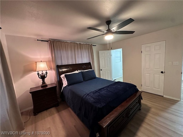 bedroom featuring a ceiling fan, baseboards, and wood finished floors