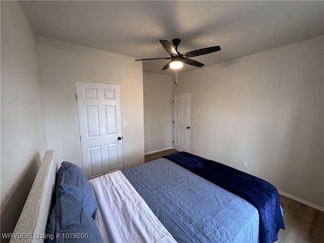 bedroom with a ceiling fan, baseboards, and wood finished floors