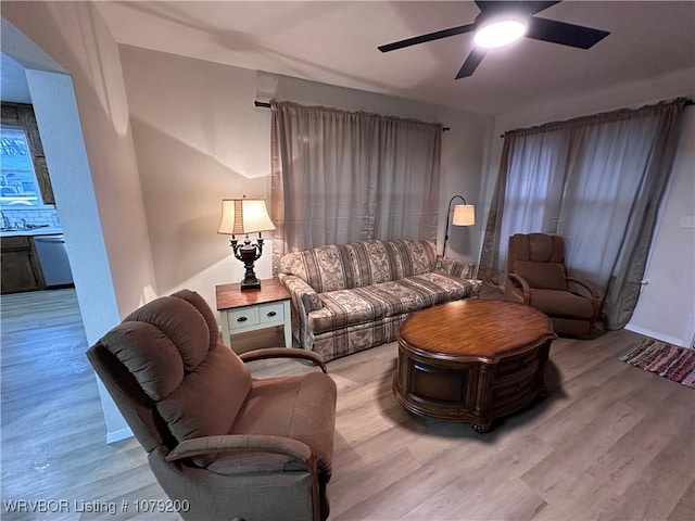 living room featuring light wood-style floors and a ceiling fan