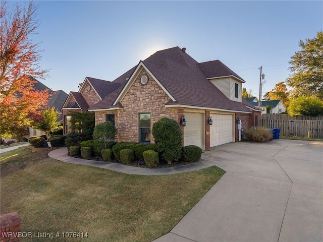 view of front of home with fence, a garage, stone siding, driveway, and a front lawn