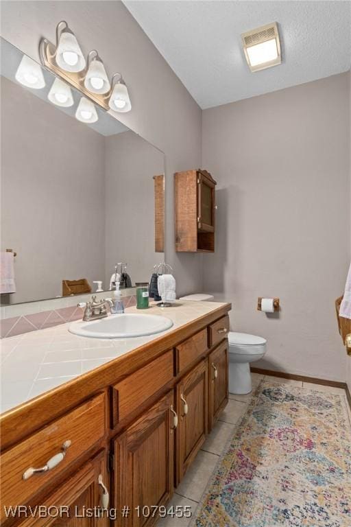 bathroom with visible vents, vanity, tile patterned flooring, and toilet