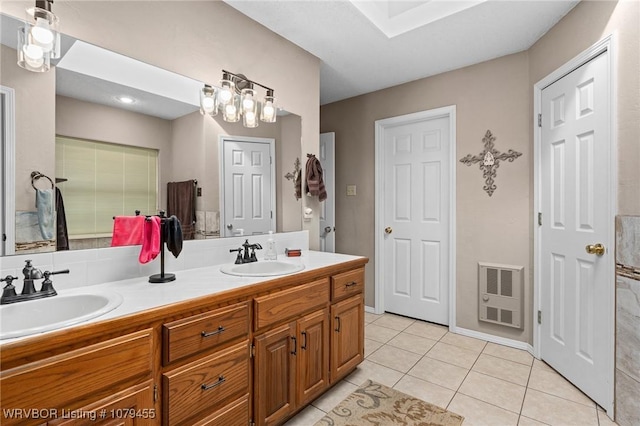 full bath featuring double vanity, tile patterned flooring, a sink, and heating unit