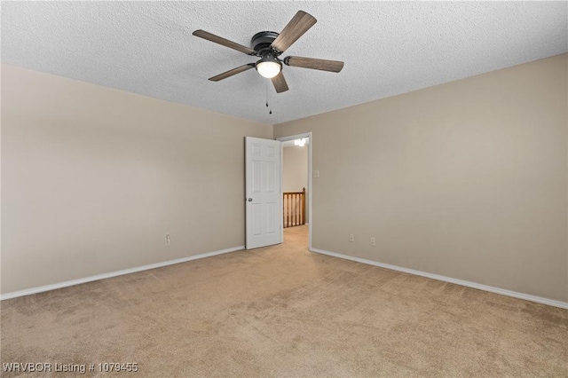 unfurnished room featuring light carpet, ceiling fan, a textured ceiling, and baseboards