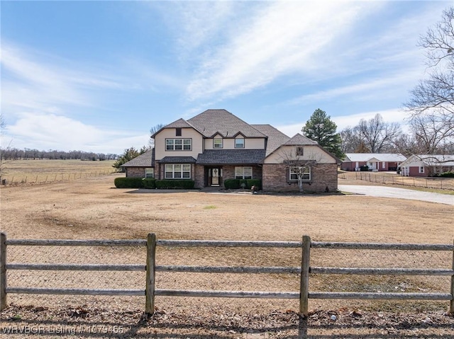 french provincial home with a rural view and a fenced front yard