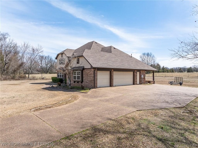 view of front of home with a garage, concrete driveway, brick siding, and roof with shingles