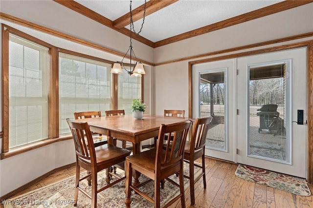 dining room featuring light wood-type flooring, baseboards, a chandelier, and beamed ceiling