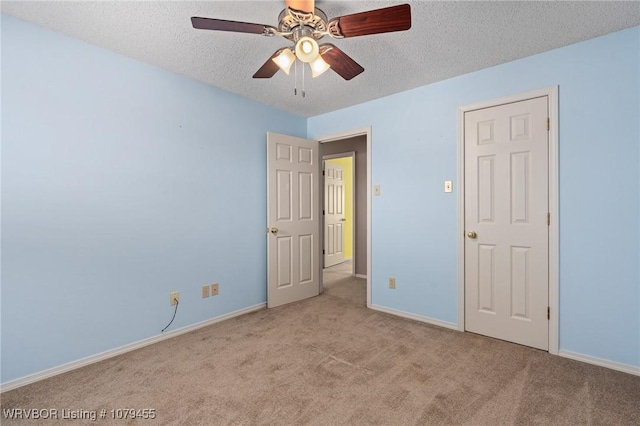 empty room featuring carpet, a textured ceiling, and baseboards