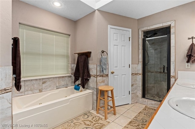 full bath featuring double vanity, a bath, tile patterned floors, a shower stall, and tile walls