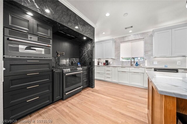 10101 Stephens Ct, Fort Smith, AR 72908 - kitchen with stainless steel range, white cabinetry, tasteful backsplash, light wood finished floors, and light stone countertops