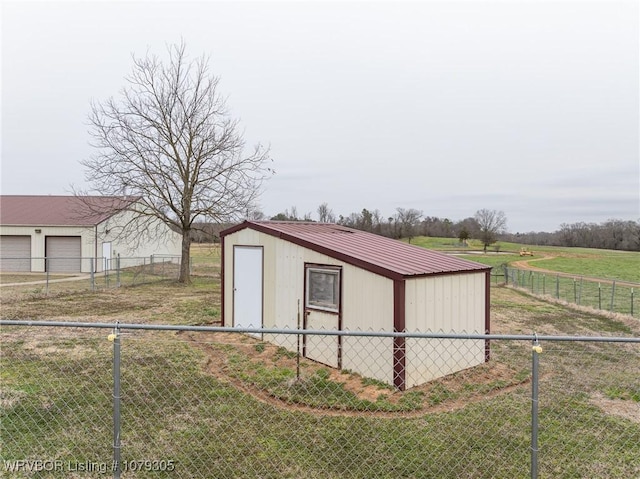 view of outdoor structure with a rural view, an outdoor structure, and fence