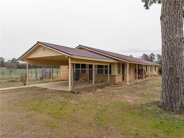 exterior space featuring brick siding, driveway, and metal roof