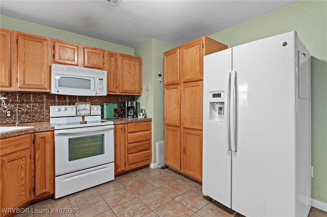 kitchen featuring visible vents, a sink, tasteful backsplash, white appliances, and light tile patterned floors