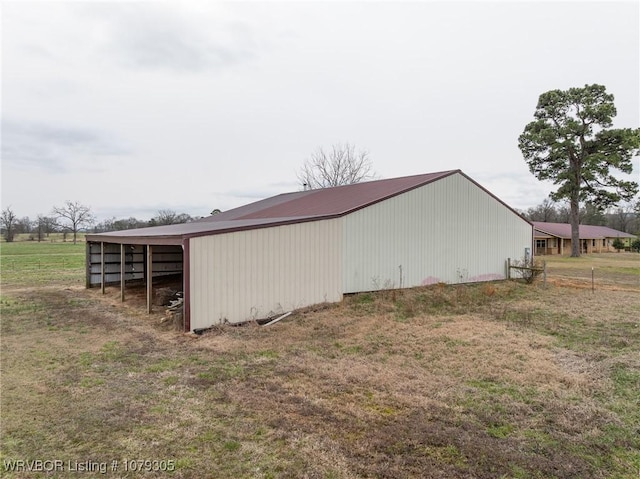 view of pole building with a carport and fence