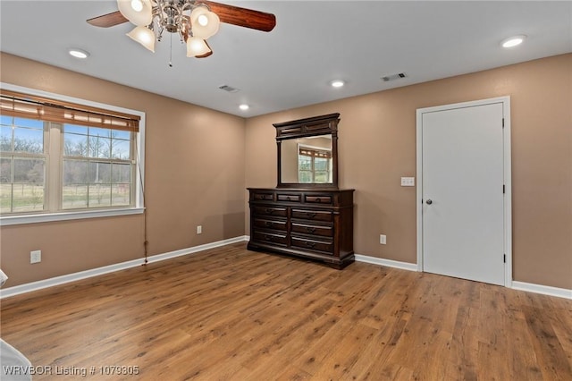 unfurnished bedroom with visible vents, baseboards, and wood finished floors