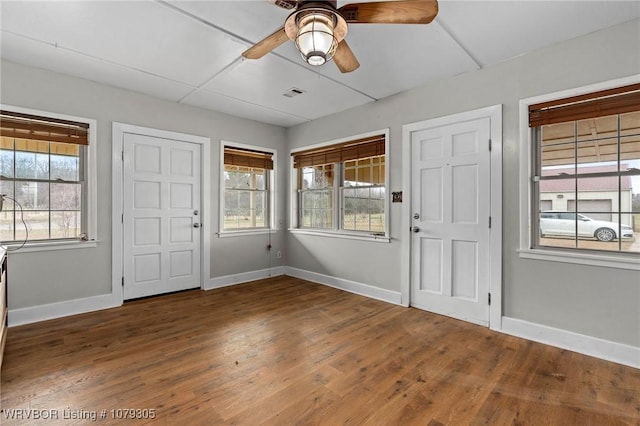 foyer with ceiling fan, visible vents, baseboards, and wood finished floors