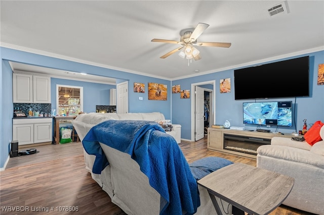 bedroom featuring crown molding, ceiling fan, and light wood-type flooring