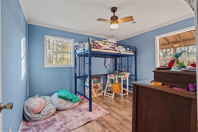 bedroom featuring crown molding, ceiling fan, and light wood-type flooring