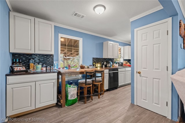 kitchen with light hardwood / wood-style flooring, ornamental molding, dishwasher, white cabinets, and backsplash