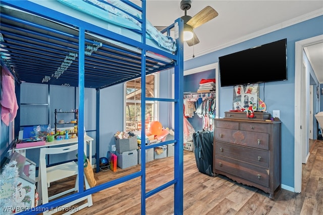 bedroom featuring light hardwood / wood-style flooring, ornamental molding, a closet, and ceiling fan