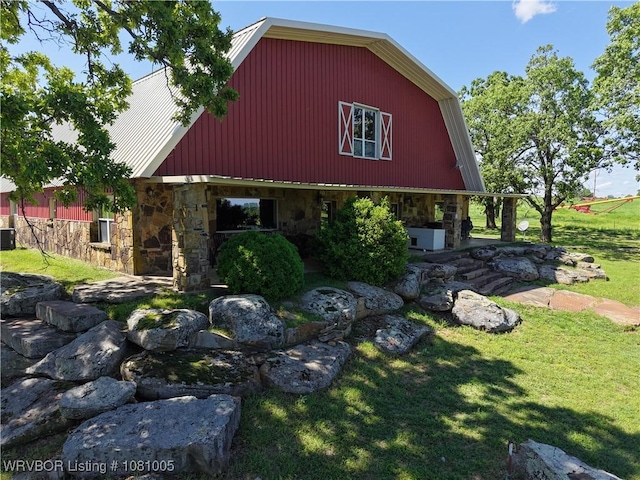 20309 E County Road 1110, Stigler, OK 74462 - view of property exterior with stone siding, a yard, cooling unit, and a barn