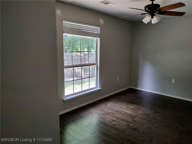 spare room featuring ceiling fan, dark hardwood / wood-style floors, and a wealth of natural light