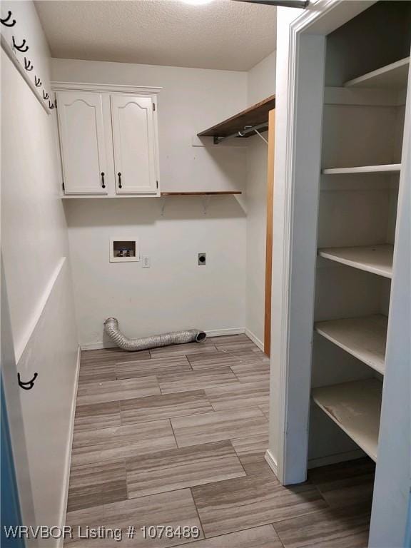 clothes washing area featuring washer hookup, cabinets, and electric dryer hookup