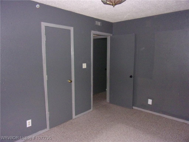 unfurnished bedroom with a textured ceiling, carpet floors, and a closet