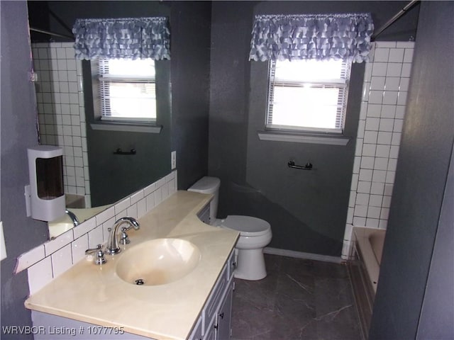 full bathroom featuring vanity, toilet, and tiled shower / bath