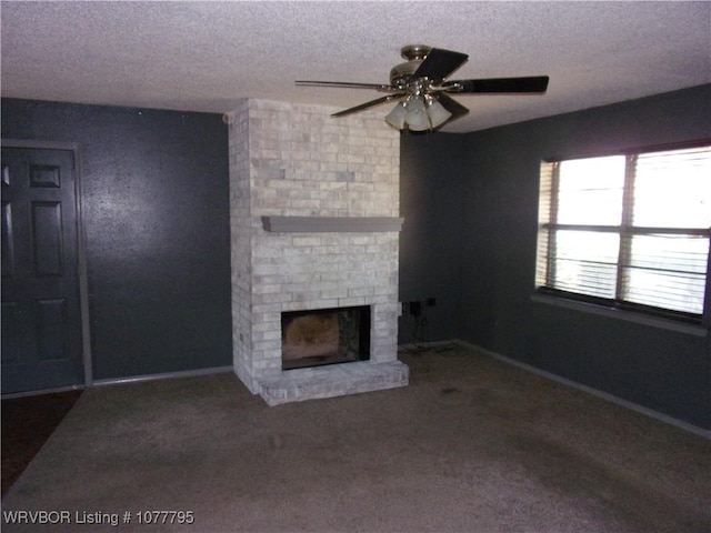 unfurnished living room with ceiling fan, carpet floors, a textured ceiling, and a brick fireplace