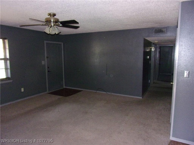 spare room with light carpet, a textured ceiling, and ceiling fan