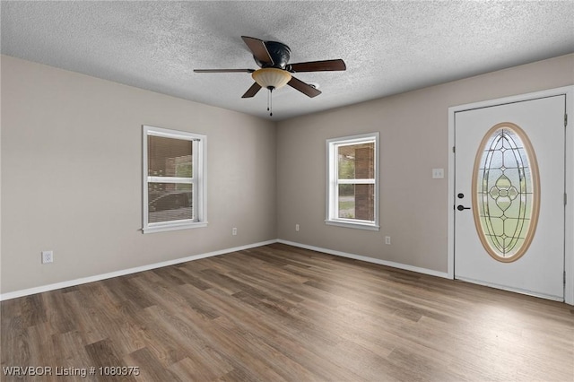 entrance foyer featuring baseboards, a ceiling fan, wood finished floors, and a textured ceiling