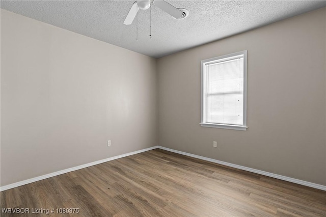 empty room with wood finished floors, baseboards, and ceiling fan