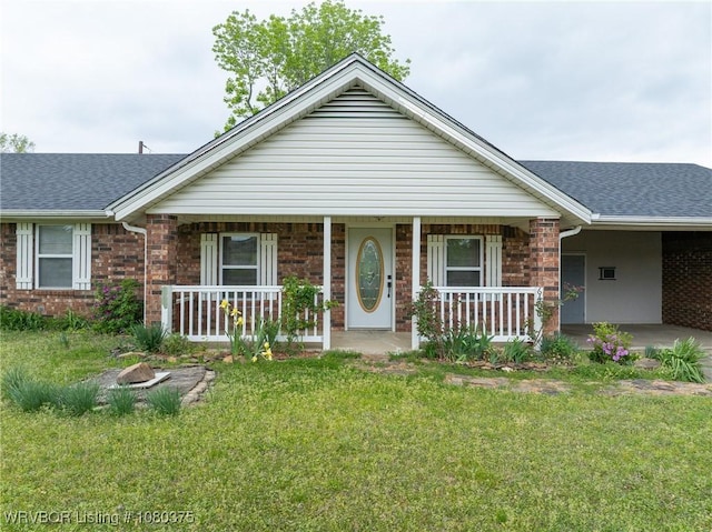 view of front of home featuring covered porch, a front yard, and roof with shingles