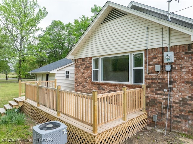 back of property featuring brick siding, central AC unit, and a deck