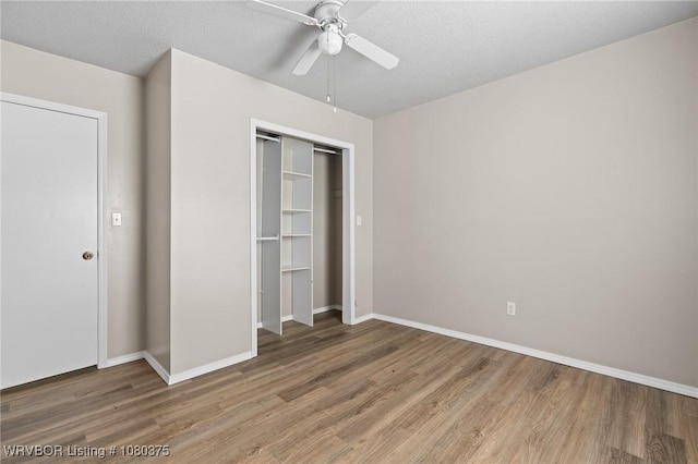 unfurnished bedroom featuring light wood-style floors, a closet, baseboards, and ceiling fan