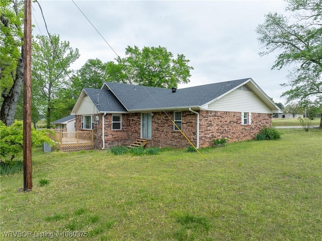 view of front of property with brick siding, a front yard, and a deck