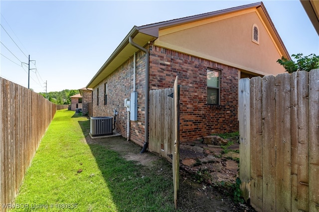 8205 Cisterna Way, Fort Smith, AR 72916 - view of side of home featuring a yard, brick siding, fence, cooling unit, and stucco siding