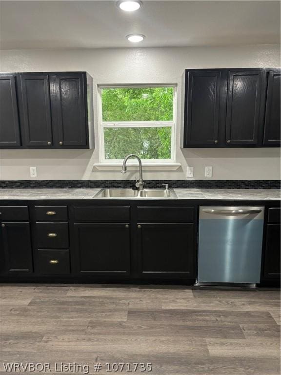 kitchen with stainless steel dishwasher, light wood-type flooring, and sink