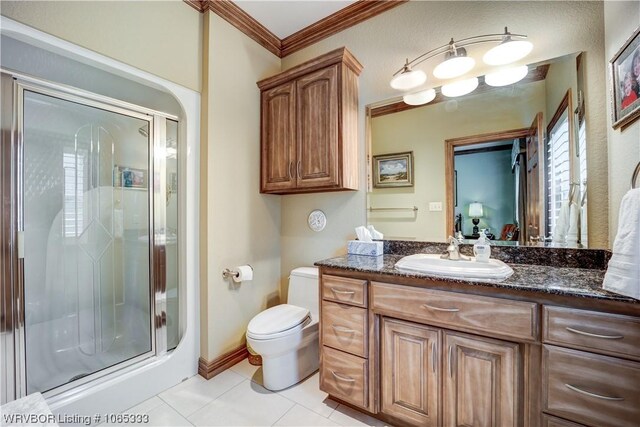 bathroom featuring vanity, tile patterned floors, a shower with door, and ornamental molding