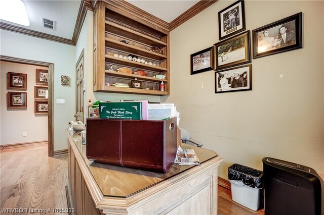 office area with light wood-type flooring and ornamental molding