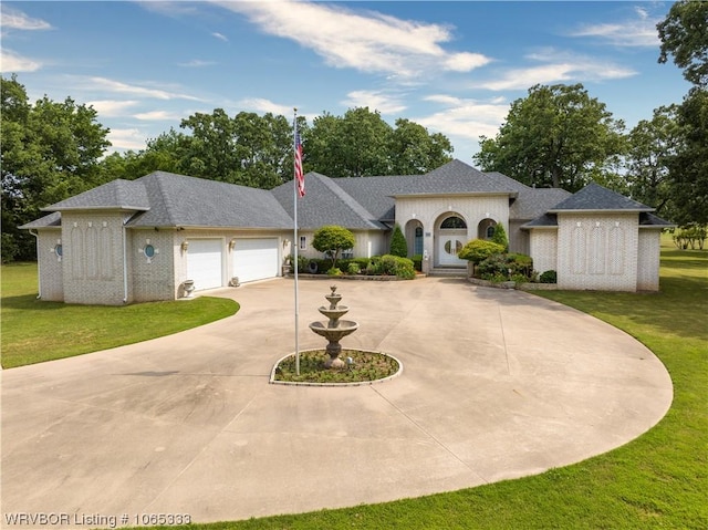 view of front of property featuring a garage and a front lawn