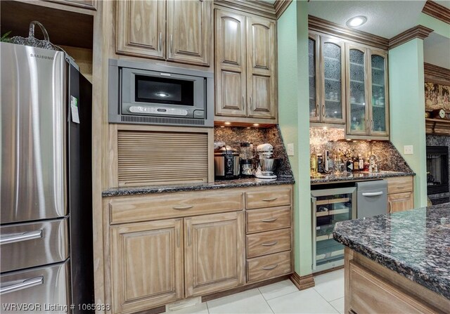 kitchen featuring backsplash, stainless steel appliances, dark stone countertops, wine cooler, and light tile patterned flooring