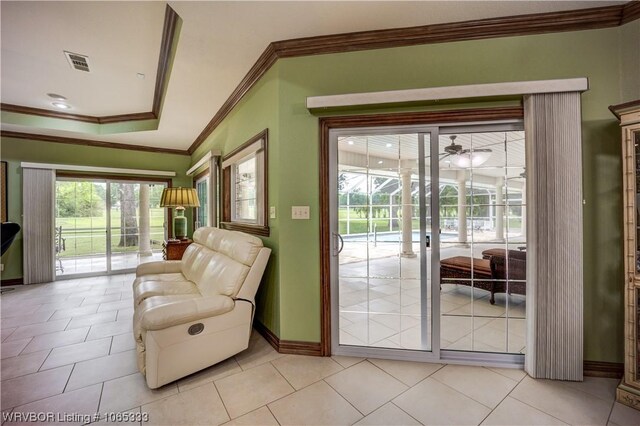 doorway featuring ceiling fan, light tile patterned floors, and crown molding