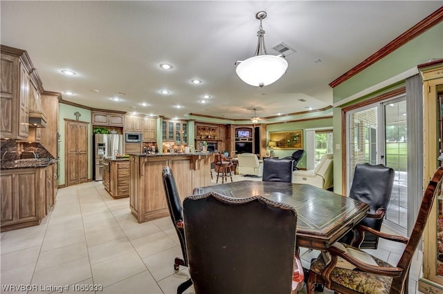 dining area with ceiling fan, french doors, light tile patterned floors, and ornamental molding