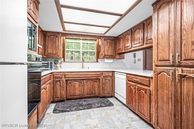 3009 Shadow Lake Dr, Greenwood, AR 72936 - kitchen featuring brown cabinets, a sink, white appliances, stone finish floor, and backsplash
