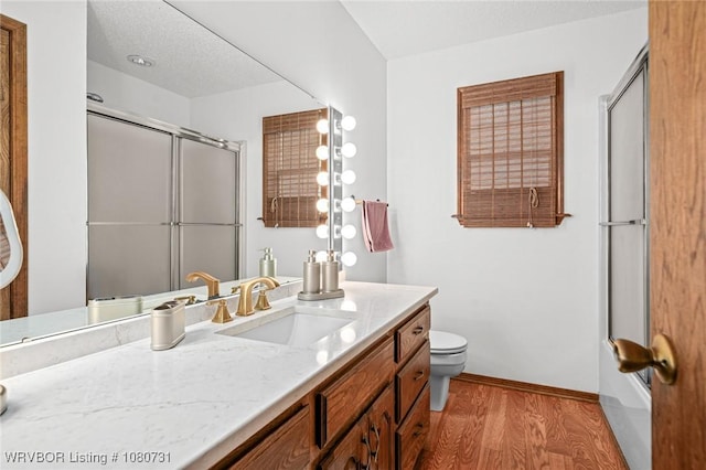 3009 Shadow Lake Dr, Greenwood, AR 72936 - full bathroom featuring vanity, a shower with door, wood finished floors, toilet, and baseboards
