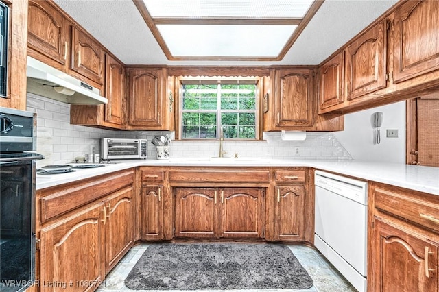 3009 Shadow Lake Dr, Greenwood, AR 72936 - kitchen with under cabinet range hood, white dishwasher, brown cabinetry, and a sink